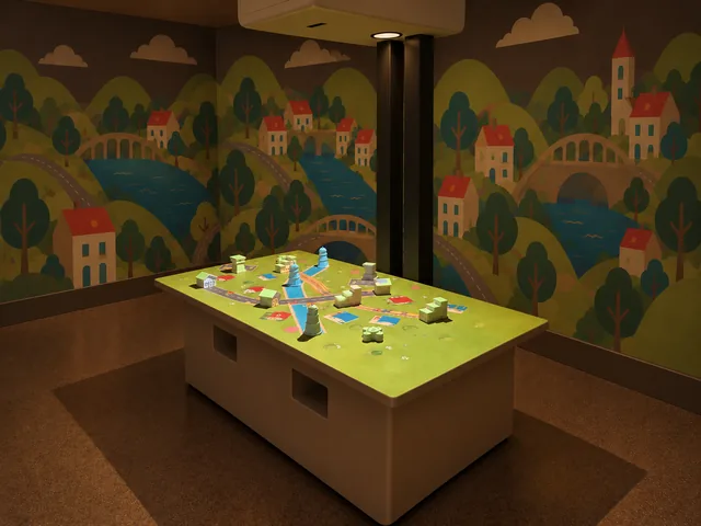Block Town table with physical building models and a projected town of roads, railway tracks and waterways.