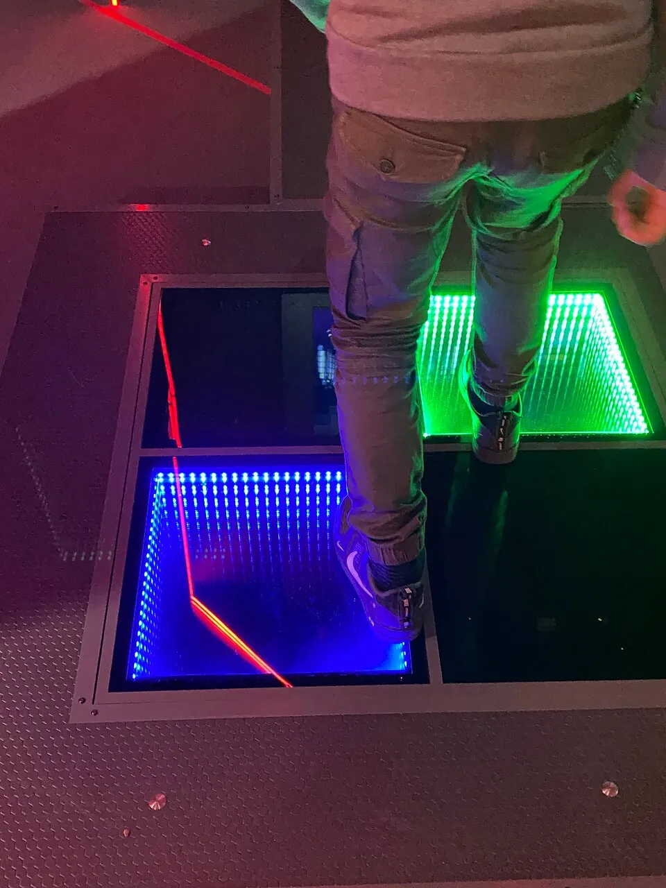Visitor stepping between illuminated Dance Floor platforms.